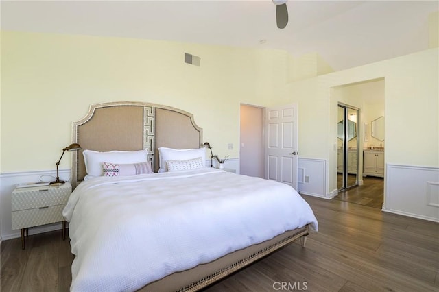 bedroom with connected bathroom, dark hardwood / wood-style floors, high vaulted ceiling, and ceiling fan