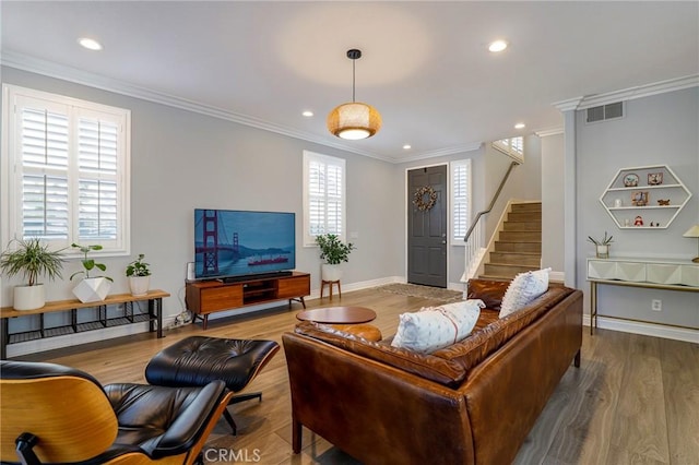 living room with wood-type flooring and ornamental molding