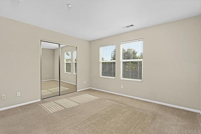 unfurnished bedroom with carpet flooring and a closet