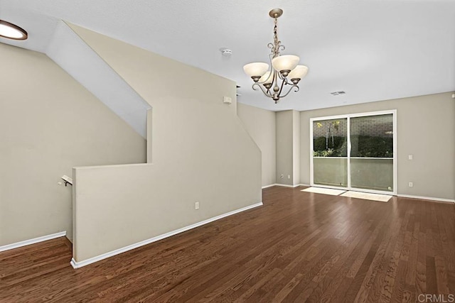 unfurnished living room with an inviting chandelier and hardwood / wood-style flooring