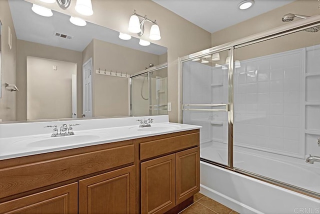 bathroom featuring tile patterned flooring, vanity, and bath / shower combo with glass door