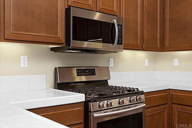 kitchen with tile countertops and appliances with stainless steel finishes