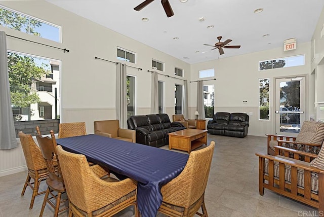 dining room with ceiling fan and a towering ceiling