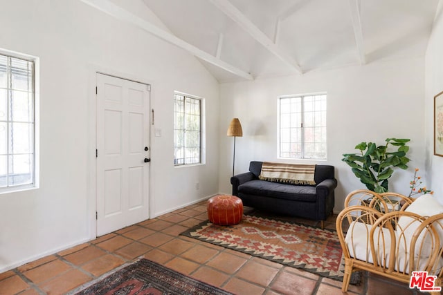 entryway with tile patterned floors and lofted ceiling with beams