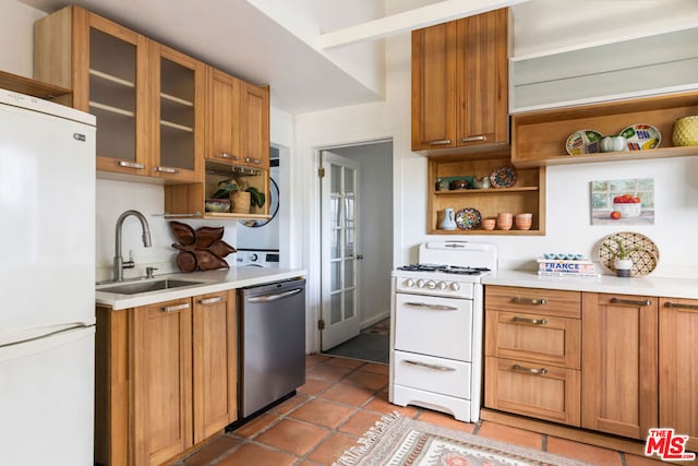 kitchen featuring tile patterned flooring, white appliances, and sink