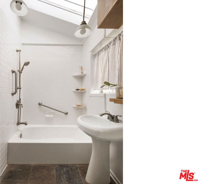 bathroom featuring tiled shower / bath combo and lofted ceiling