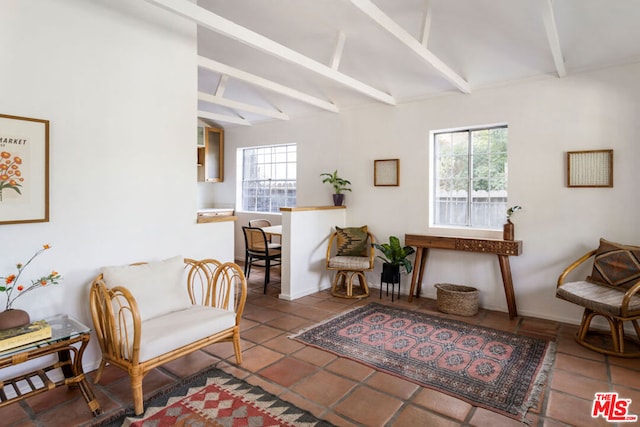 sitting room with beam ceiling, a wealth of natural light, and tile patterned floors