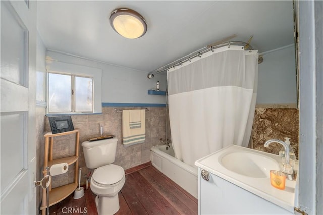 full bathroom featuring vanity, shower / bath combo with shower curtain, hardwood / wood-style flooring, tile walls, and toilet