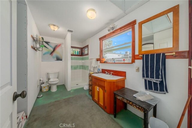 bathroom featuring vanity, curtained shower, toilet, and concrete floors