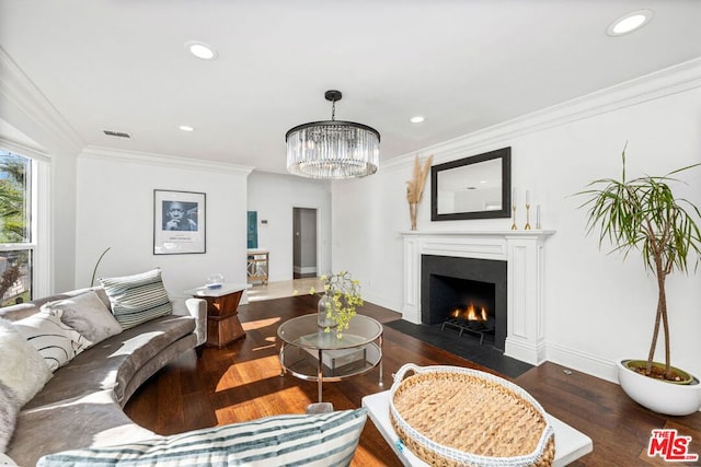 living room with a notable chandelier, crown molding, and dark wood-type flooring