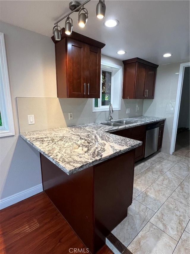 kitchen featuring sink, light hardwood / wood-style flooring, stainless steel dishwasher, and light stone counters