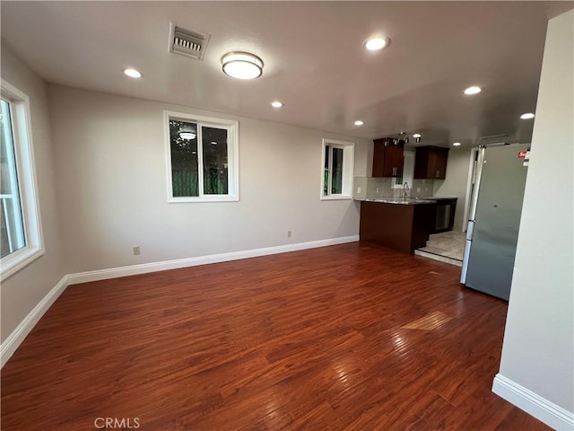 unfurnished living room with dark hardwood / wood-style flooring and sink