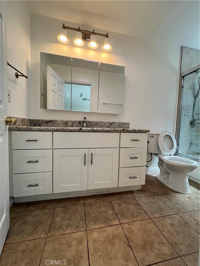 bathroom with tile patterned floors, a shower with door, vanity, and toilet