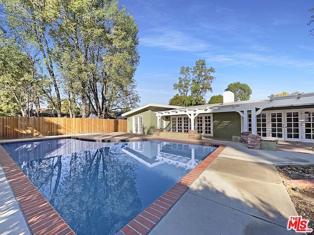 view of swimming pool with french doors and a patio