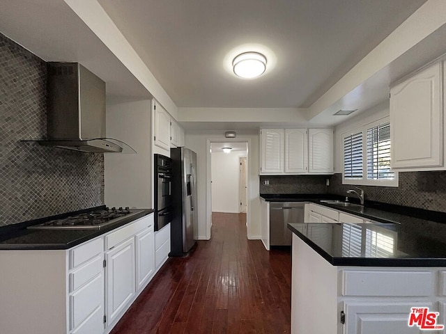 kitchen featuring white cabinets, appliances with stainless steel finishes, dark hardwood / wood-style flooring, and wall chimney exhaust hood