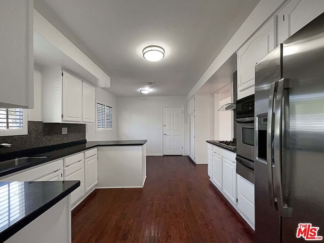 kitchen with dark wood-type flooring, sink, decorative backsplash, appliances with stainless steel finishes, and white cabinetry