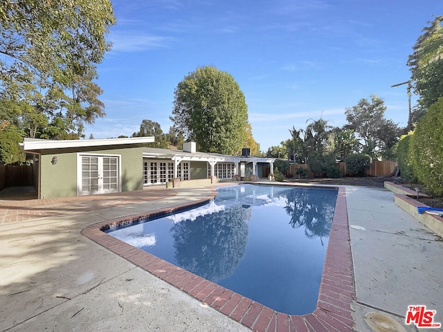 view of swimming pool with a patio area and french doors