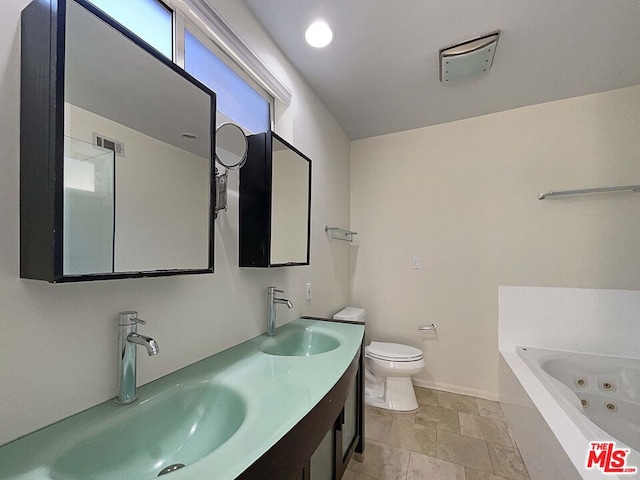 bathroom featuring a tub to relax in, vanity, and toilet