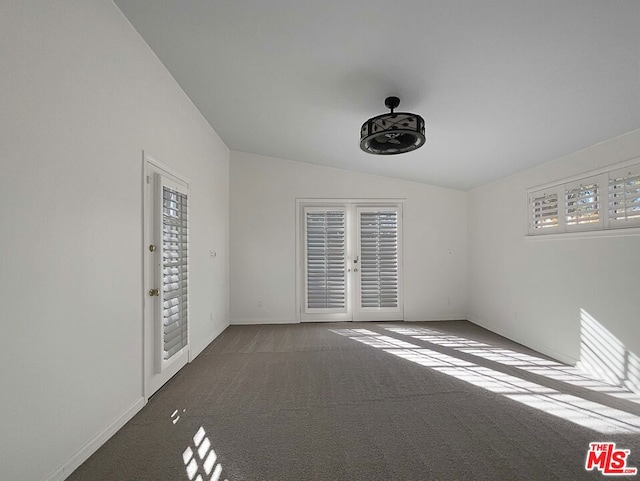 empty room with carpet, french doors, and vaulted ceiling