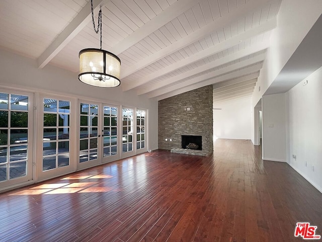 unfurnished living room featuring a fireplace, dark hardwood / wood-style flooring, a healthy amount of sunlight, and vaulted ceiling with beams