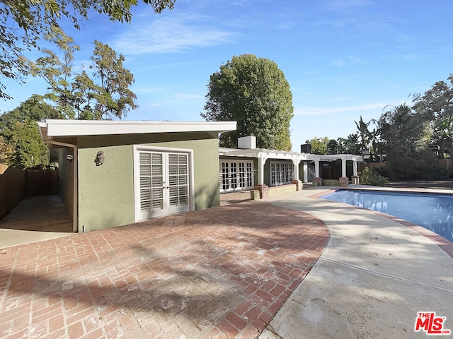 back of house featuring a pergola, a patio area, and a fenced in pool