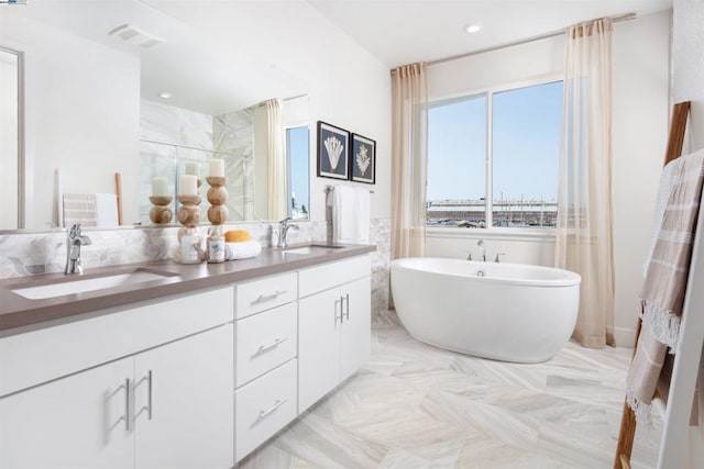 bathroom featuring vanity and a tub to relax in