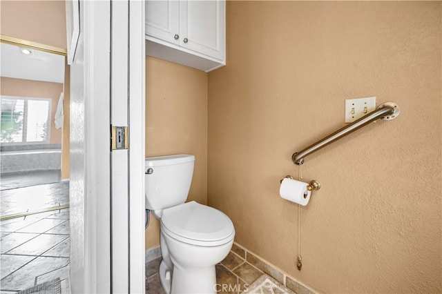 bathroom featuring toilet and tile patterned flooring