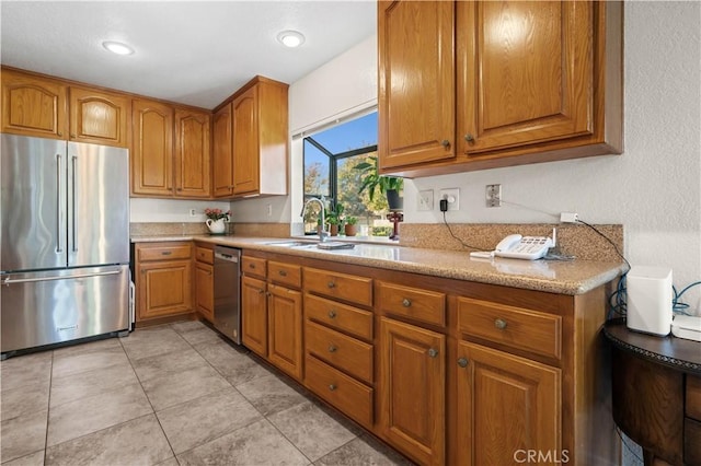 kitchen featuring light stone counters, sink, and appliances with stainless steel finishes