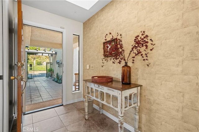 entryway with tile patterned floors and a skylight