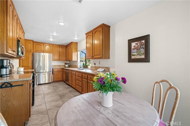 kitchen featuring sink, light tile patterned floors, and appliances with stainless steel finishes