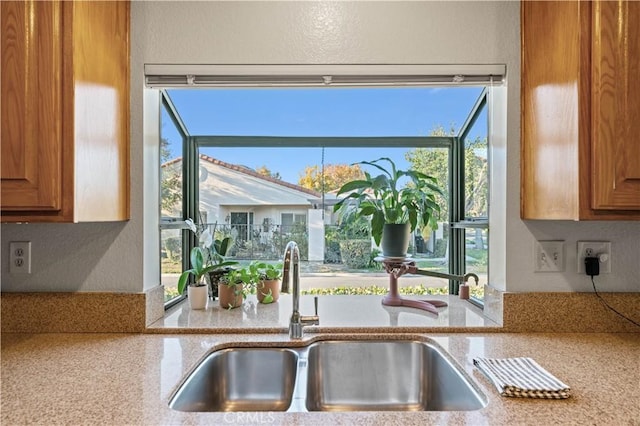 kitchen with light stone counters and sink