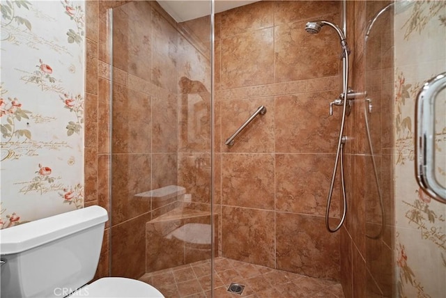 bathroom with toilet and a tile shower