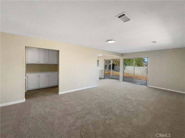 unfurnished living room featuring a chandelier and carpet floors