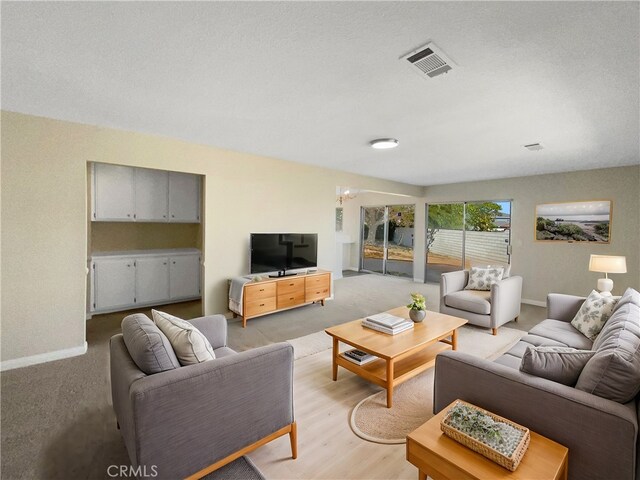 living room featuring light hardwood / wood-style flooring and a textured ceiling