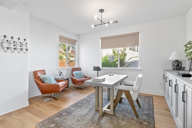 dining room with an inviting chandelier and light hardwood / wood-style flooring