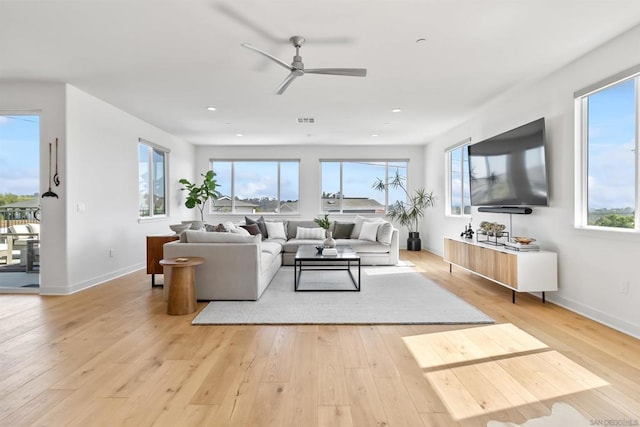 living room featuring ceiling fan and light hardwood / wood-style floors