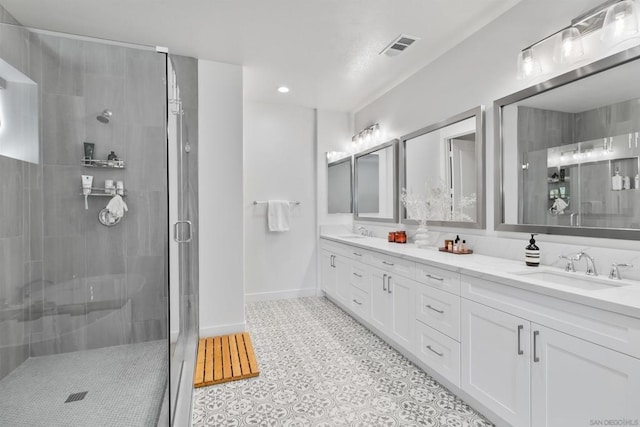 bathroom featuring a shower with door and vanity