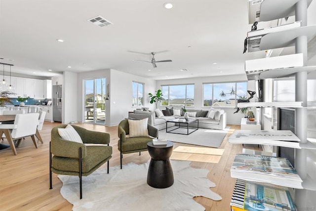 living room featuring ceiling fan and light wood-type flooring