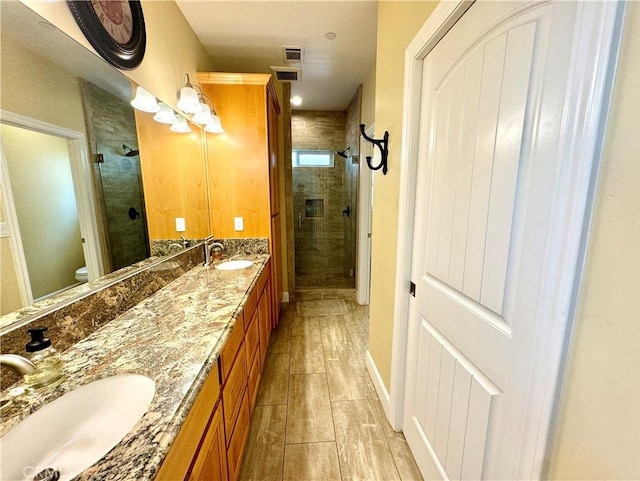 bathroom featuring vanity, wood-type flooring, an enclosed shower, and toilet