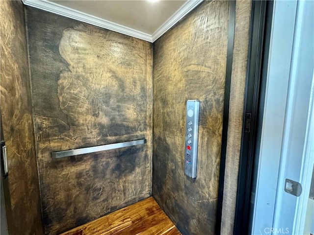 interior details with elevator, hardwood / wood-style flooring, and ornamental molding