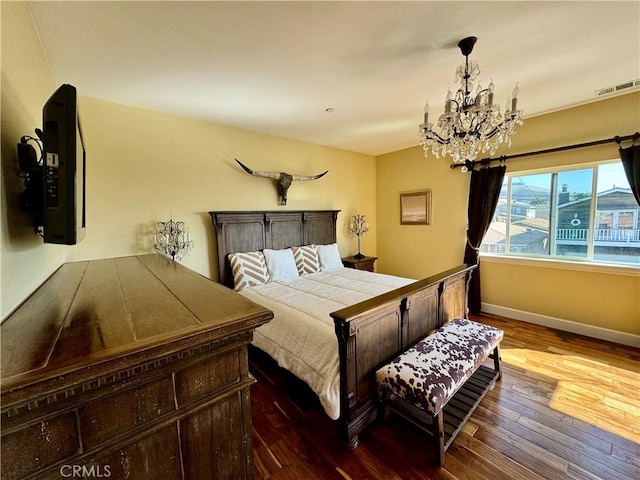 bedroom featuring hardwood / wood-style floors and an inviting chandelier