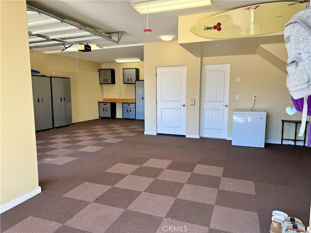 garage with a garage door opener and fridge