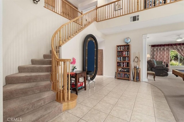 stairs featuring tile patterned floors, ceiling fan, a high ceiling, and pool table