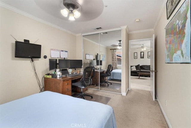 carpeted bedroom featuring ceiling fan, ornamental molding, and a closet