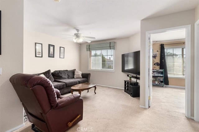 living room featuring a wealth of natural light, ceiling fan, and light colored carpet