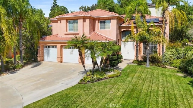 mediterranean / spanish-style home featuring a front yard and a garage