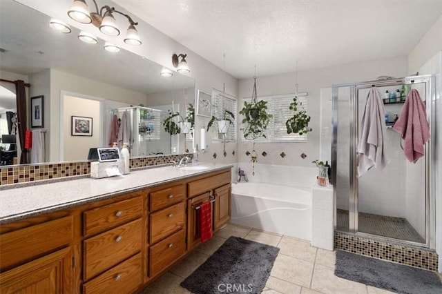 bathroom with plus walk in shower, plenty of natural light, vanity, and tile patterned flooring