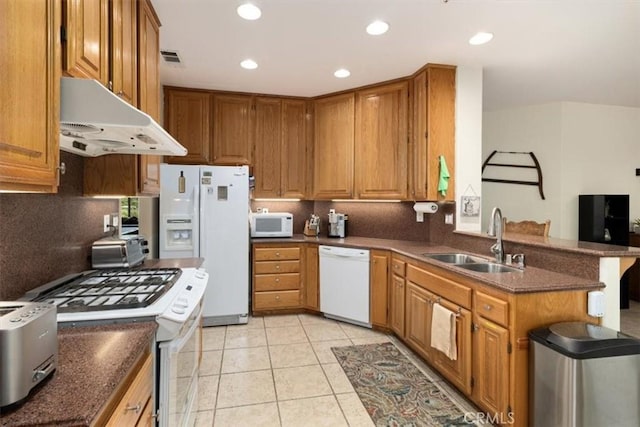 kitchen with light tile patterned flooring, white appliances, kitchen peninsula, and sink