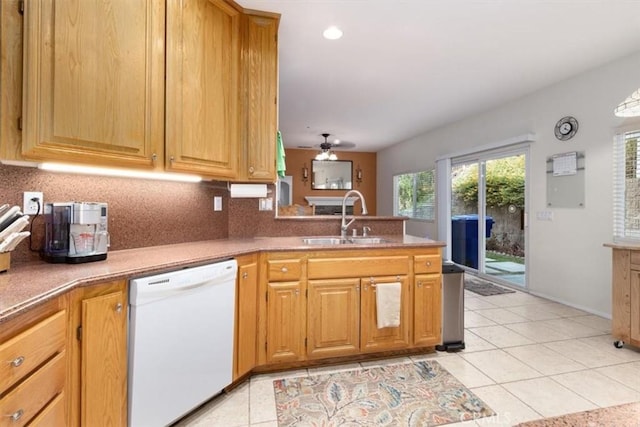 kitchen with kitchen peninsula, white dishwasher, ceiling fan, sink, and light tile patterned flooring