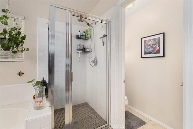 bathroom featuring tile patterned flooring, toilet, and independent shower and bath